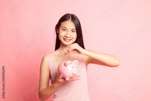 Asian woman with coin and pig coin bank.