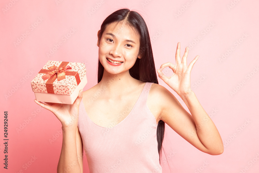 Young Asian woman show OK with a gift box.