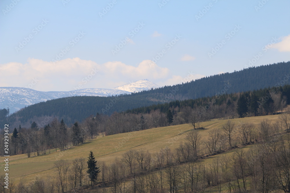 Obraz premium Rudawy Janowickie Mountains during spring. Karkonosze Mountains, Śnieżka Mountain (snow-covered) in the background. Warm, sunny, calm day. Lower Silesia, Dolny Śląsk, Poland, Polska, Polen