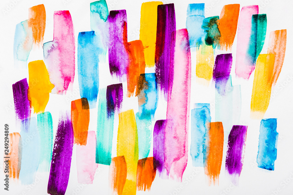 Top view of pink, purple, yellow, blue and orange brushstrokes on white background
