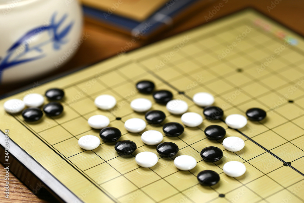 Chinese go game board, close up view of playing black and white stone pieces Chinese go game board, close up view of playing black and white stone pieces