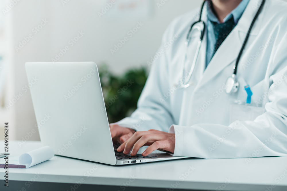 Detail of Young Doctor on the Job working on laptop Detail of Young Doctor on the Job working on laptop