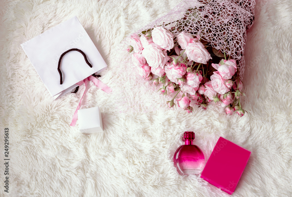 box with a gift, a package, a perfume and a bouquet of pink roses box with a gift, a package, a perfume and a bouquet of pink roses