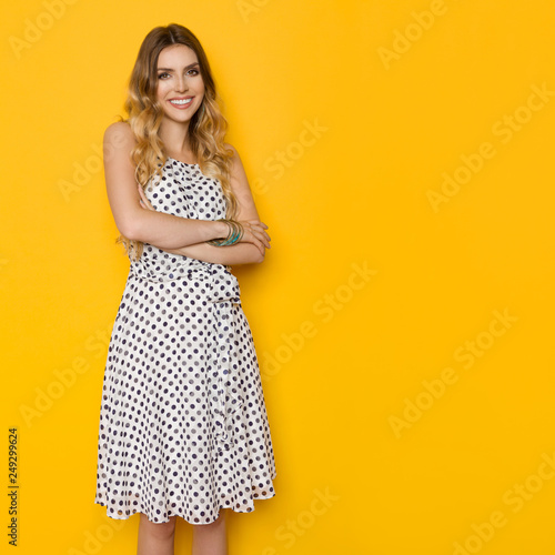 Beautiful Young Woman In Summer Dotted Dress Is Posing With Arms Crossed