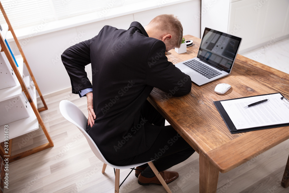 Man Having Backpain Working On Laptop In Office Man Having Backpain Working On Laptop In Office