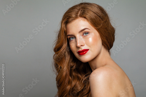 Pretty redhead woman face. Red head girl with curly hairstyle. Ginger hair, red lips makeup. Natural authentic beauty