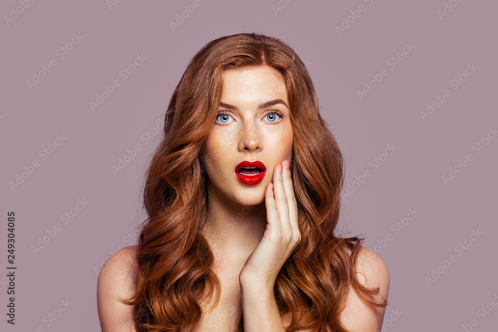 Fototapeta premium Surprised woman with beautiful red hair on bright pink background. Redhead girl with opened mouth portrait