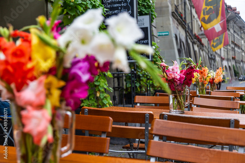 Tables outside the cafe decorated with bouquets of gladioli in Bern, Switzerland