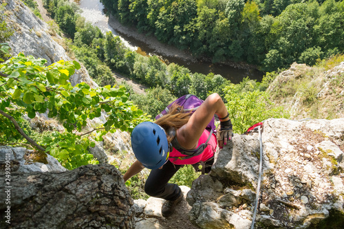 Woman tourist climbing a via ferrata route called 