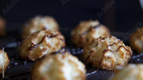 Chocolate sauce being drizzled on golden bitesize coconut cakes photo