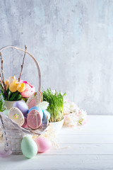 Easter greeting card with glazed cookies and colorful easter eggs in basket . With copy space