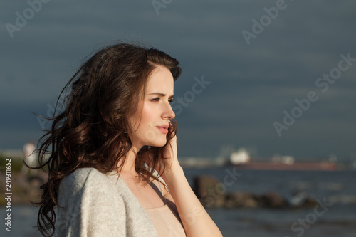 Woman outdoor. Pretty model girl walking along the coastline of the sea