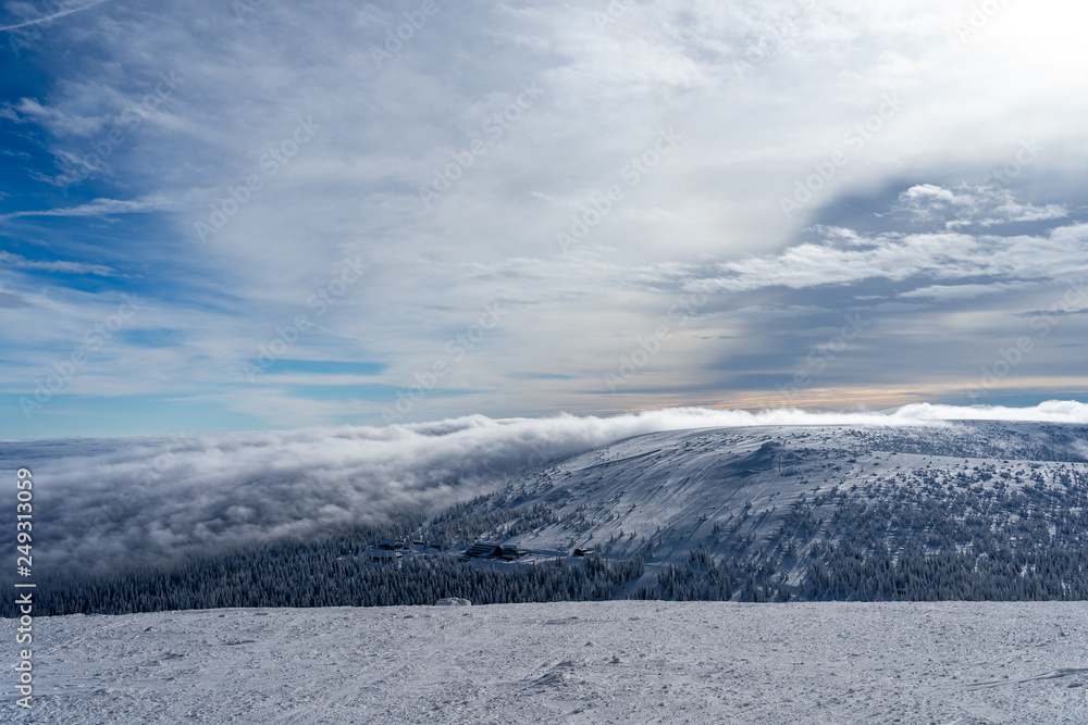 The low clouds over high mountains at winter day.