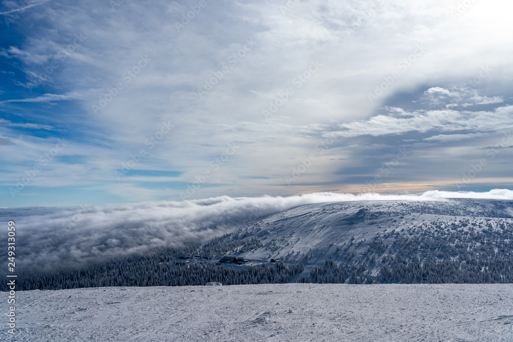 The low clouds over high mountains at winter day. The low clouds over high mountains at winter day.