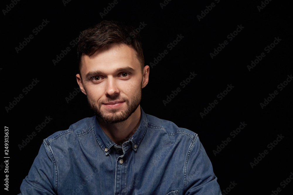 Handsome man in denim shirt looking at camera Handsome man in denim shirt looking at camera
