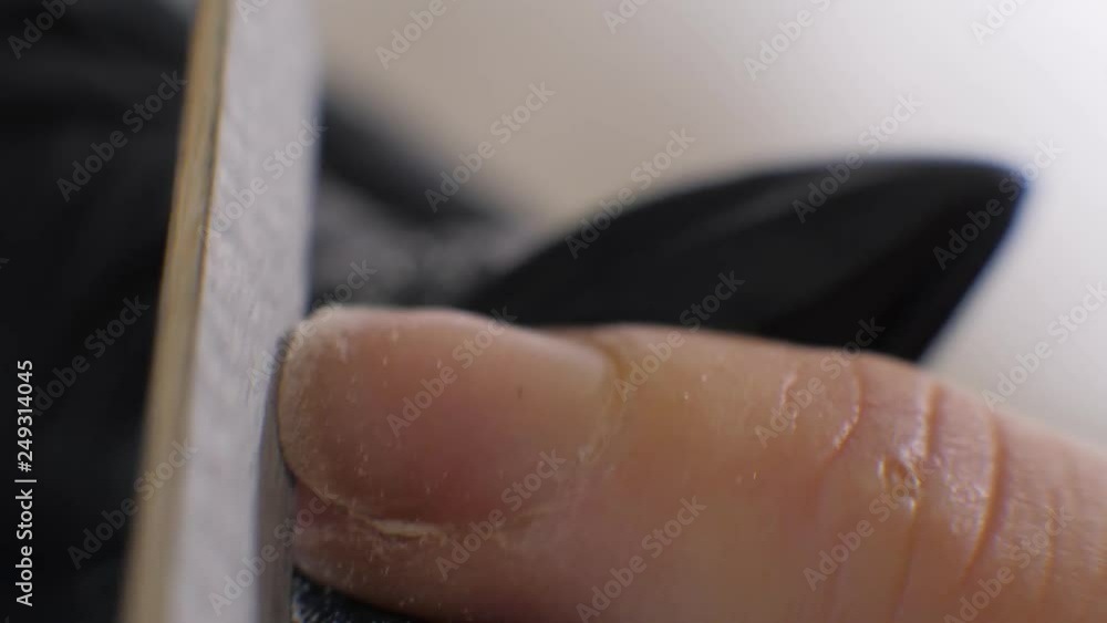 Closeup macro woman in a nail salon receiving a manicure by a beautician with nail file close up. Woman getting nail manicure. Beautician file nails to a customer. Closeup macro woman in a nail salon receiving a manicure by a beautician with nail file close up. Woman getting nail manicure. Beautician file nails to a customer.
