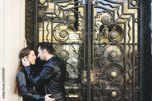 Couple in love kissing in the doorway of a building on the street without caring about the looks.