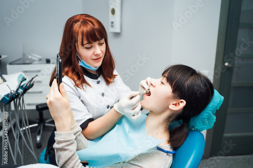 Wallpaper Mural Dental clinic. Reception, examination of the patient. Teeth care. Young woman undergoes a dental examination by a dentist Torontodigital.ca