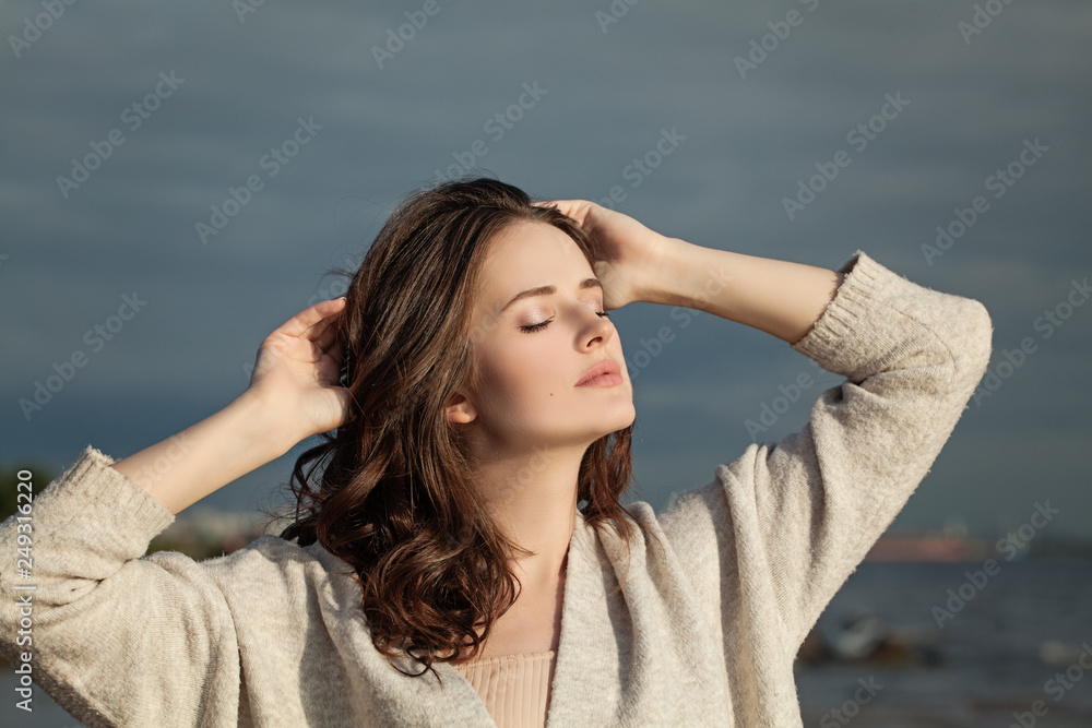 Beautiful woman enjoying the spring sun. Perfect brunette girl outdoors portrait