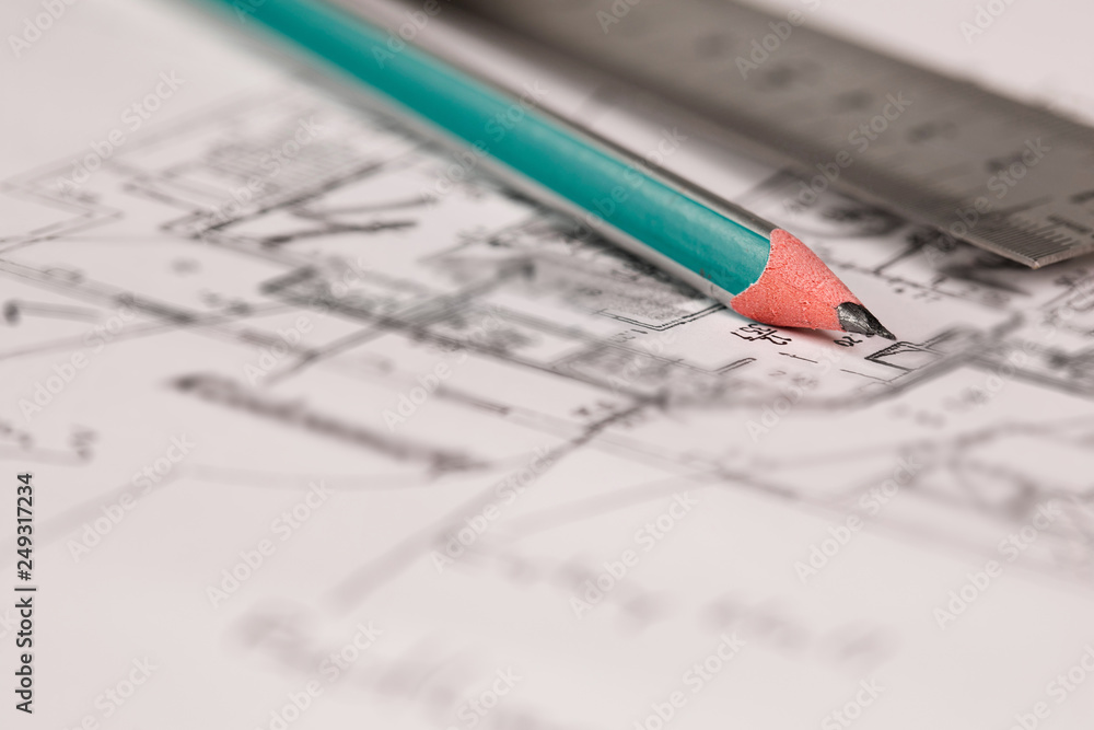 Coal pencil and metal ruler on a technical drawing of an apartment. Coal pencil and metal ruler on a technical drawing of an apartment.
