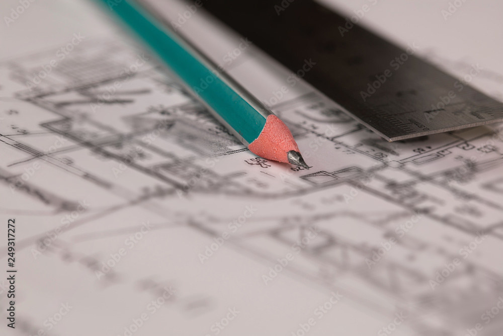 Coal pencil and metal ruler on a technical drawing of an apartment. Coal pencil and metal ruler on a technical drawing of an apartment.