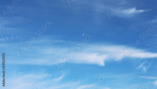 Photography blue sky with nice cirrus clouds and the moon in the middle