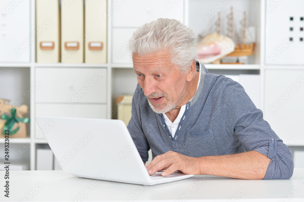 Portrait of a senior man using laptop at home Portrait of a senior man using laptop at home