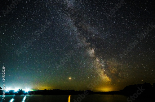 Starry sky and the milky way over the water.Bright star Mars.