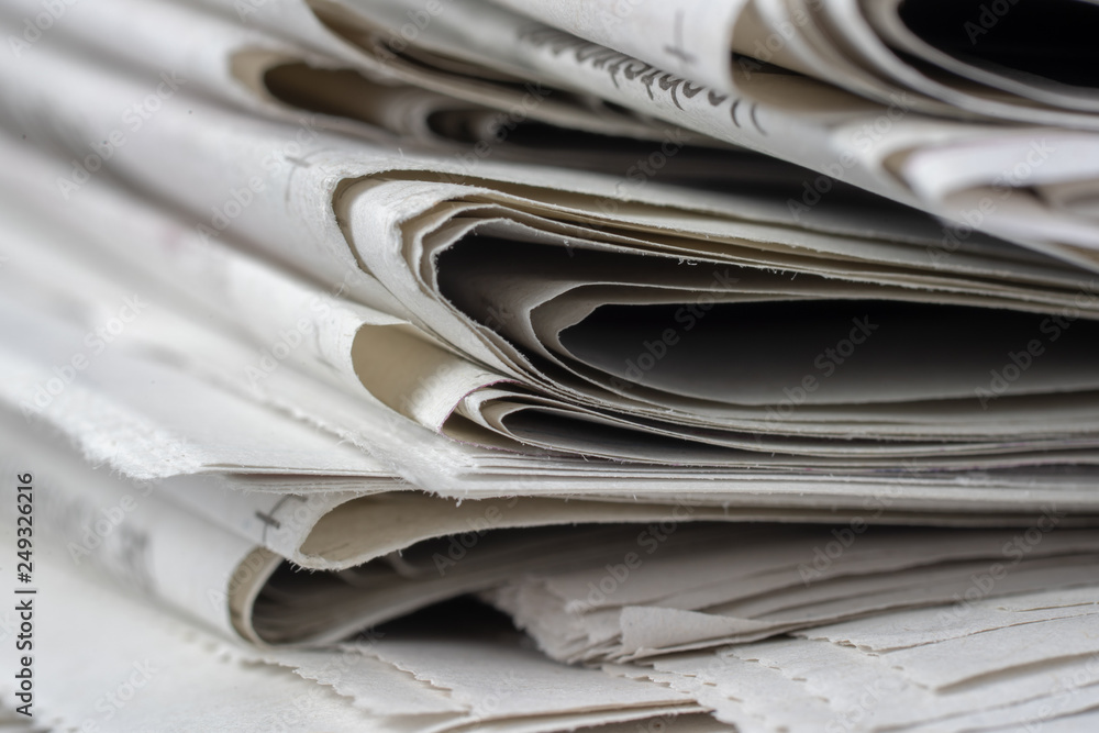 Macro shot of a stack of newspapers. The newspapers are folded Macro shot of a stack of newspapers. The newspapers are folded
