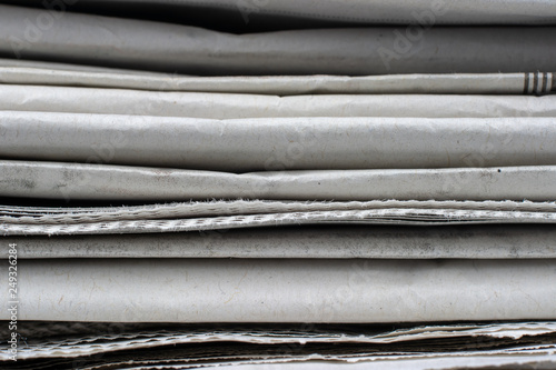 Macro shot of a stack of newspapers. The newspapers are folded
