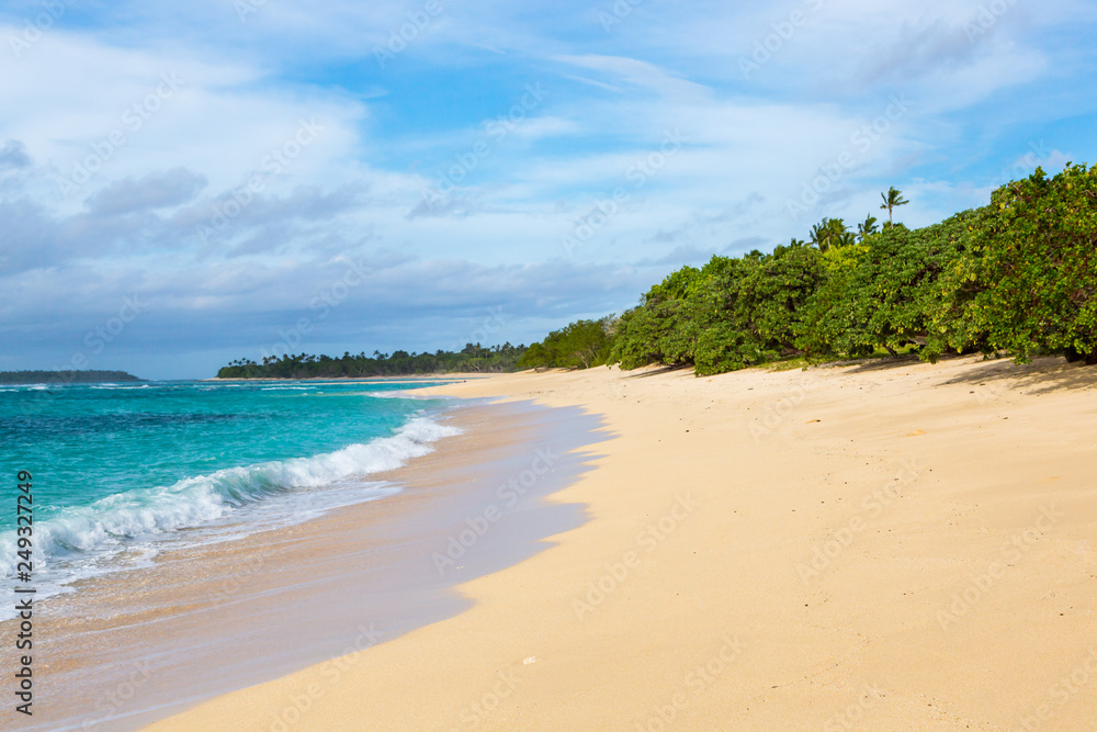 Shore of an azure, turquoise, blue lagoon. Waves, surf, swash at a remote empty idyllic sandy beach on Foa island, Haapai (Haʻapai or Ha'apai) group, Tonga, Oceania, South Pacific Ocean. Near Lifuka. Shore of an azure, turquoise, blue lagoon. Waves, surf, swash at a remote empty idyllic sandy beach on Foa island, Haapai (Haʻapai or Ha'apai) group, Tonga, Oceania, South Pacific Ocean. Near Lifuka.