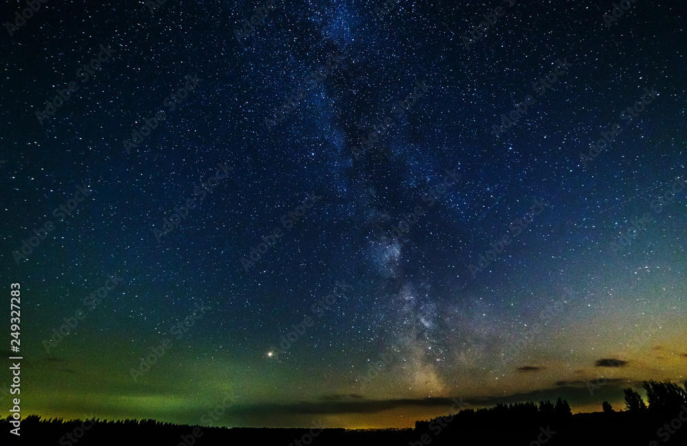 Fototapeta premium Starry sky and the milky way over the field.