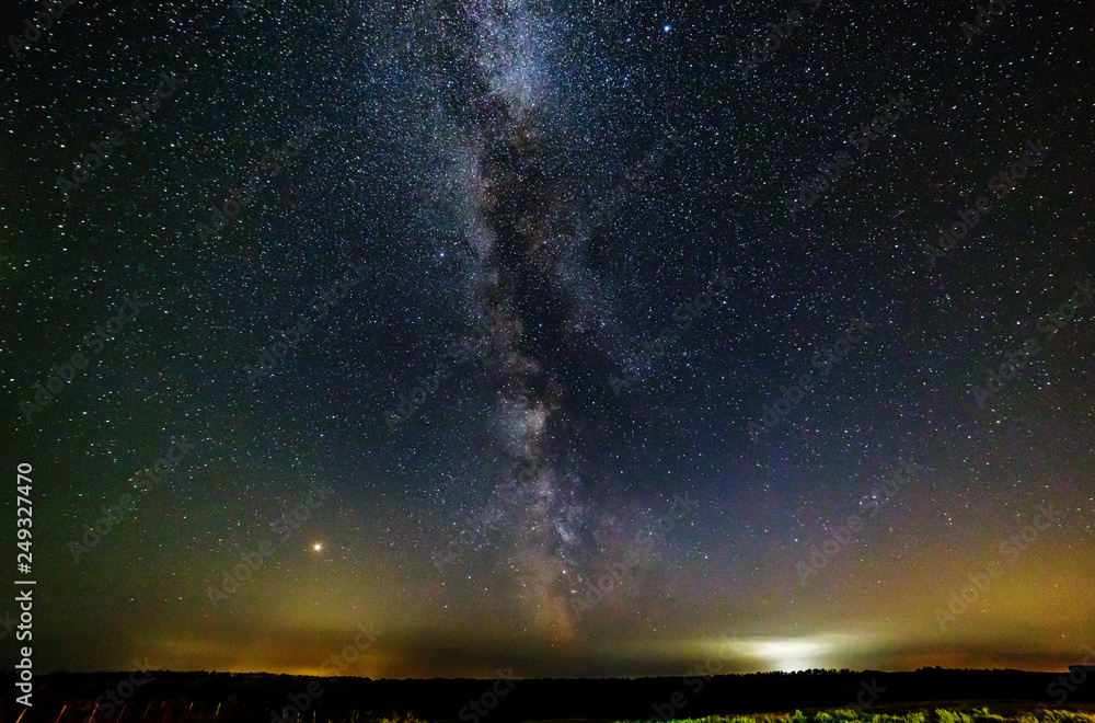 Starry sky and the milky way over the field.