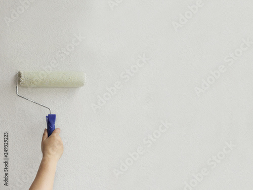 paint roller paints a white wall