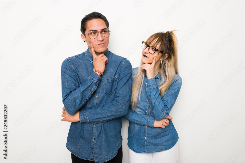 Young couple with glasses thinking an idea while looking up Young couple with glasses thinking an idea while looking up