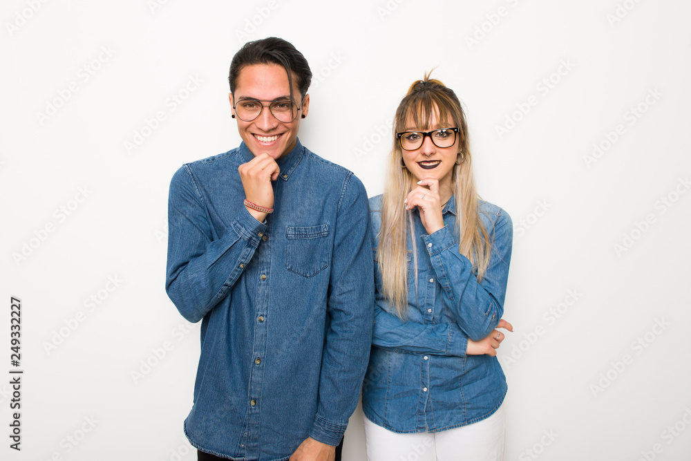 Young couple with glasses smiling and looking to the front with confident face Young couple with glasses smiling and looking to the front with confident face