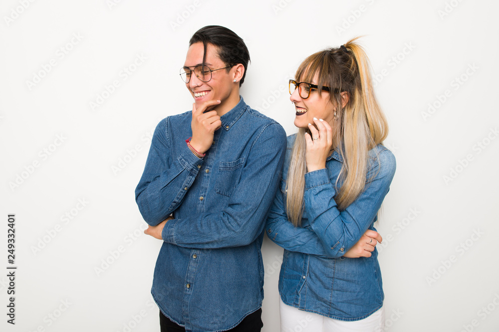 Young couple with glasses looking to the side with the hand on the chin Young couple with glasses looking to the side with the hand on the chin