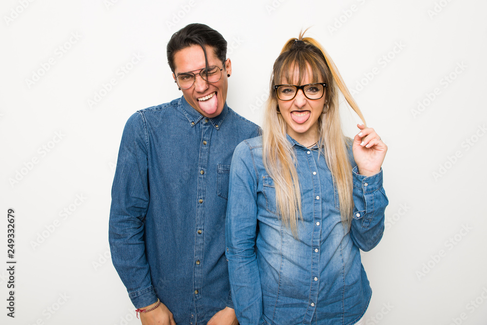 Young couple with glasses showing tongue at the camera having funny look Young couple with glasses showing tongue at the camera having funny look