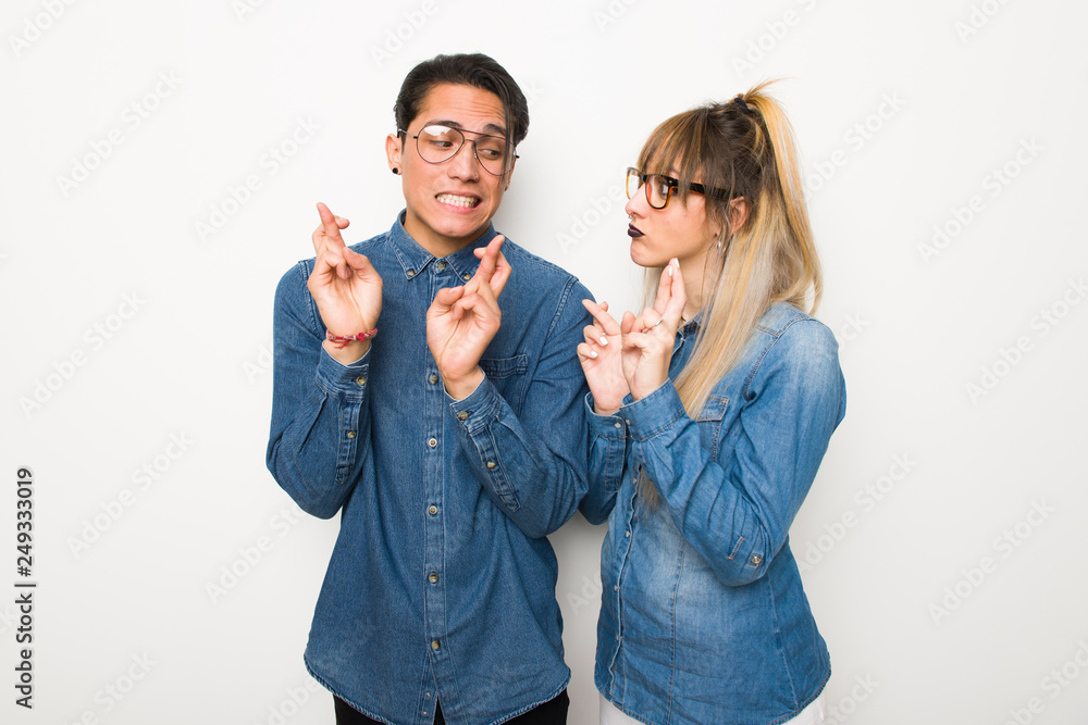 Young couple with glasses with fingers crossing and wishing the best Young couple with glasses with fingers crossing and wishing the best