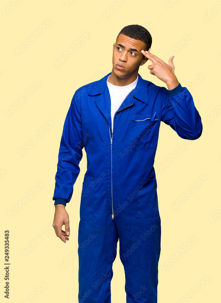 Young afro american worker man with problems making suicide gesture on isolated background Young afro american worker man with problems making suicide gesture on isolated background