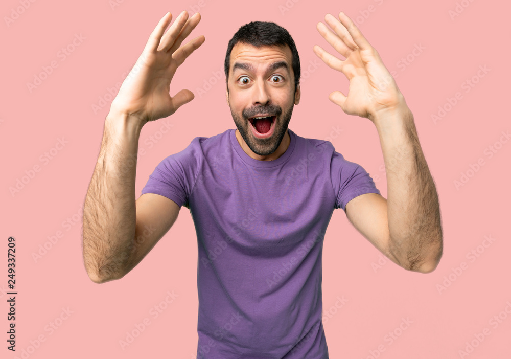 Handsome man with surprise and shocked facial expression on isolated pink background Handsome man with surprise and shocked facial expression on isolated pink background