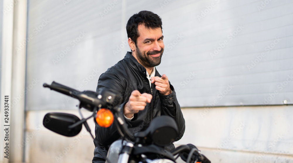 Young man on a motorbike pointing to the front Young man on a motorbike pointing to the front