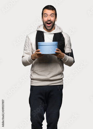 Sport man surprised because has been given a gift over isolated grey background