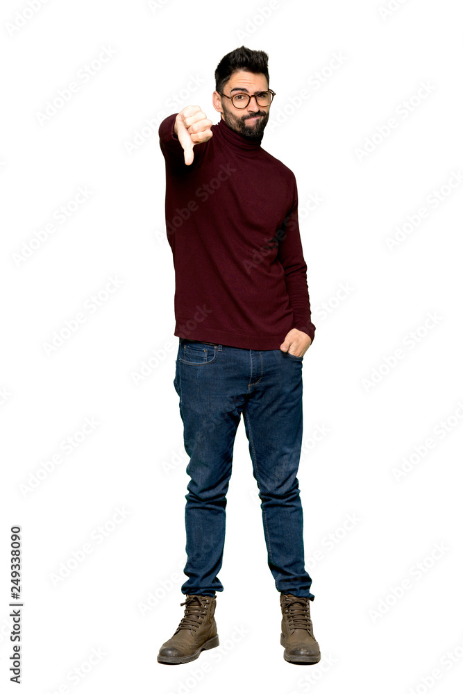 Full-length shot of Handsome man with glasses showing thumb down sign with negative expression on isolated white background Full-length shot of Handsome man with glasses showing thumb down sign with negative expression on isolated white background