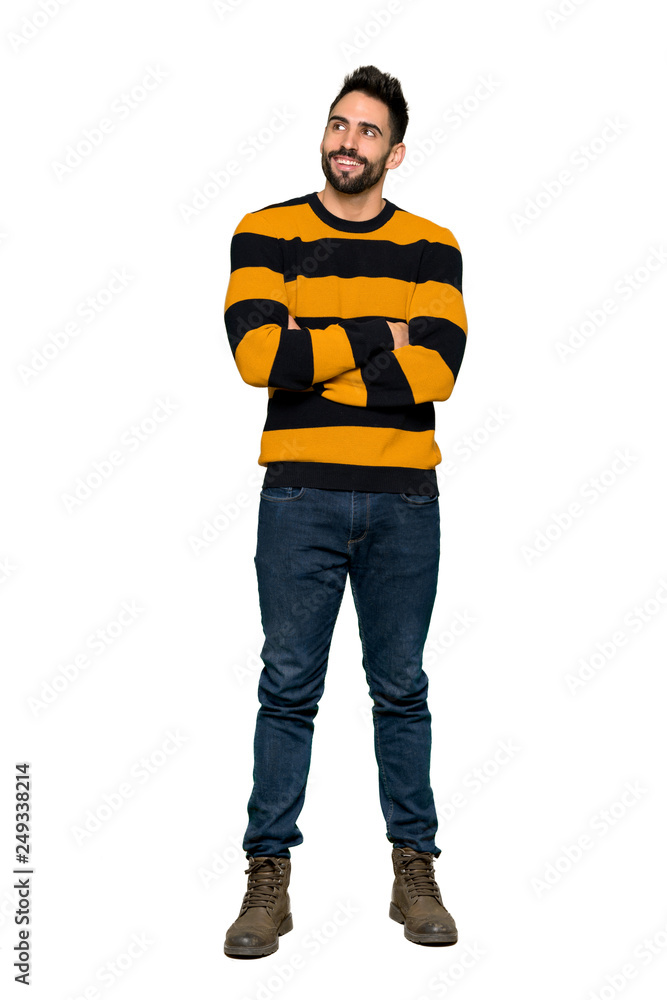 Full-length shot of Handsome man with striped sweater looking up while smiling on isolated white background Full-length shot of Handsome man with striped sweater looking up while smiling on isolated white background