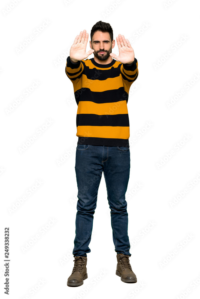 Full-length shot of Handsome man with striped sweater making stop gesture for disappointed with an opinion on isolated white background Full-length shot of Handsome man with striped sweater making stop gesture for disappointed with an opinion on isolated white background