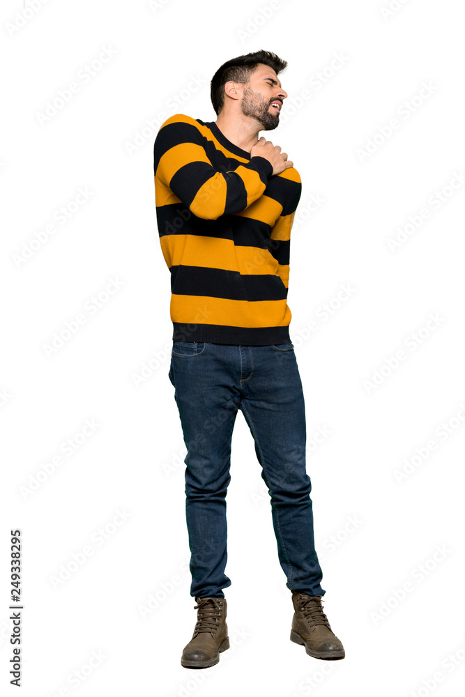 Full-length shot of Handsome man with striped sweater suffering from pain in shoulder for having made an effort on isolated white background Full-length shot of Handsome man with striped sweater suffering from pain in shoulder for having made an effort on isolated white background