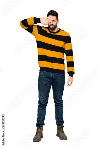 Full-length shot of Handsome man with striped sweater with tired and sick expression on isolated white background © luismolinero