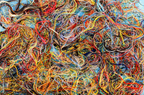 Colorful tangled threads on blue background. Closeup. photo