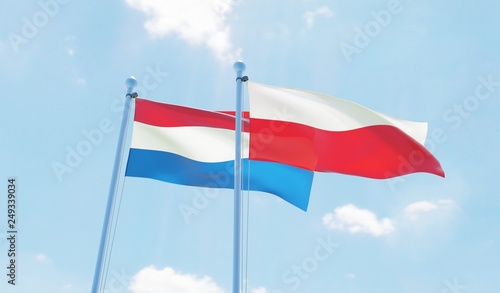 Poland and Netherlands, two flags waving against blue sky. 3d image